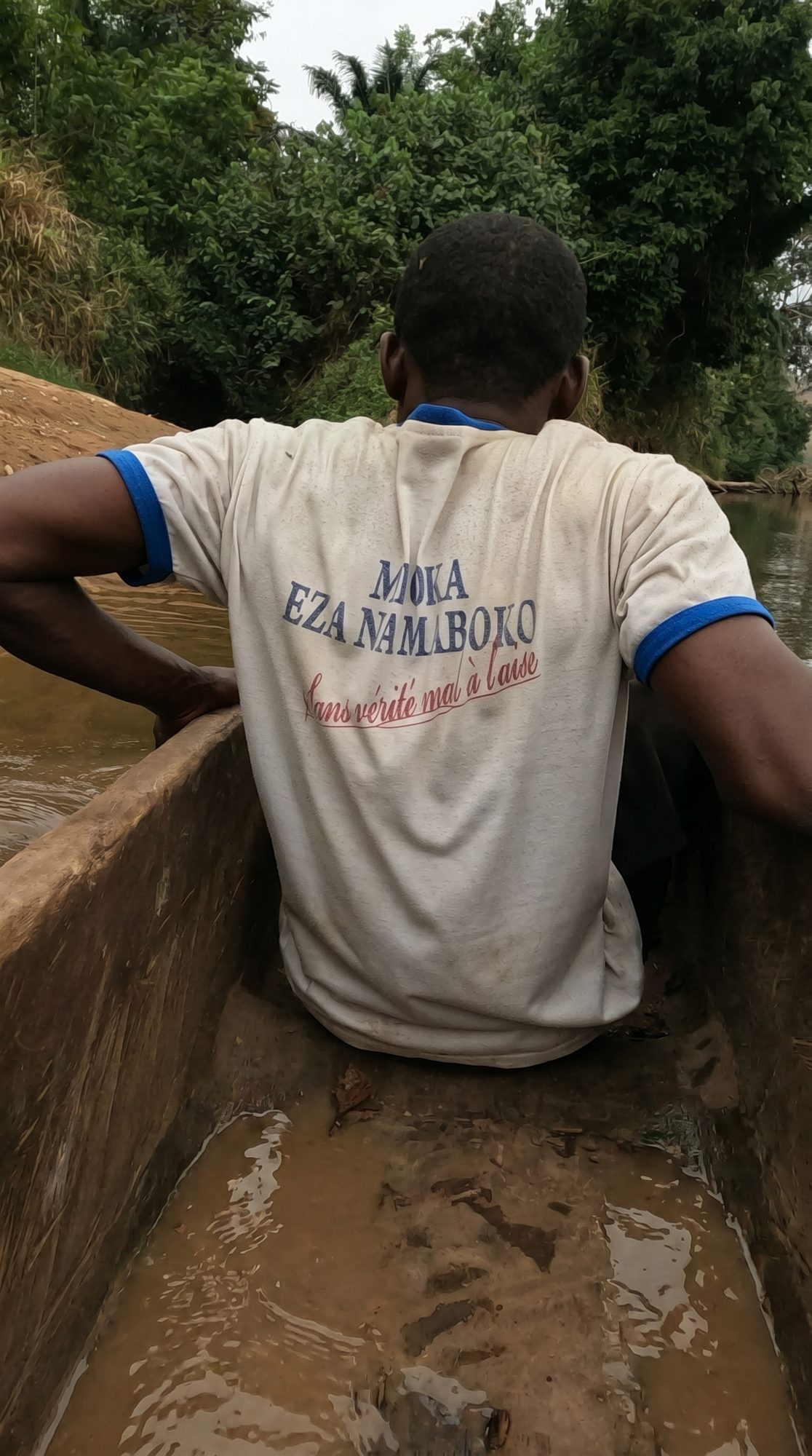 Membre de l'équipe Yelessa traversant la rivière en pirogue